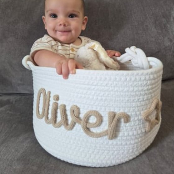 Customer photo: a baby sitting in a basket with the name Oliver