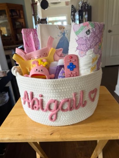 Customer photo: a basket with the name Abigail filled with toys