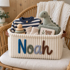 Cream corduroy basket with the name Noah in blue and brown yarn